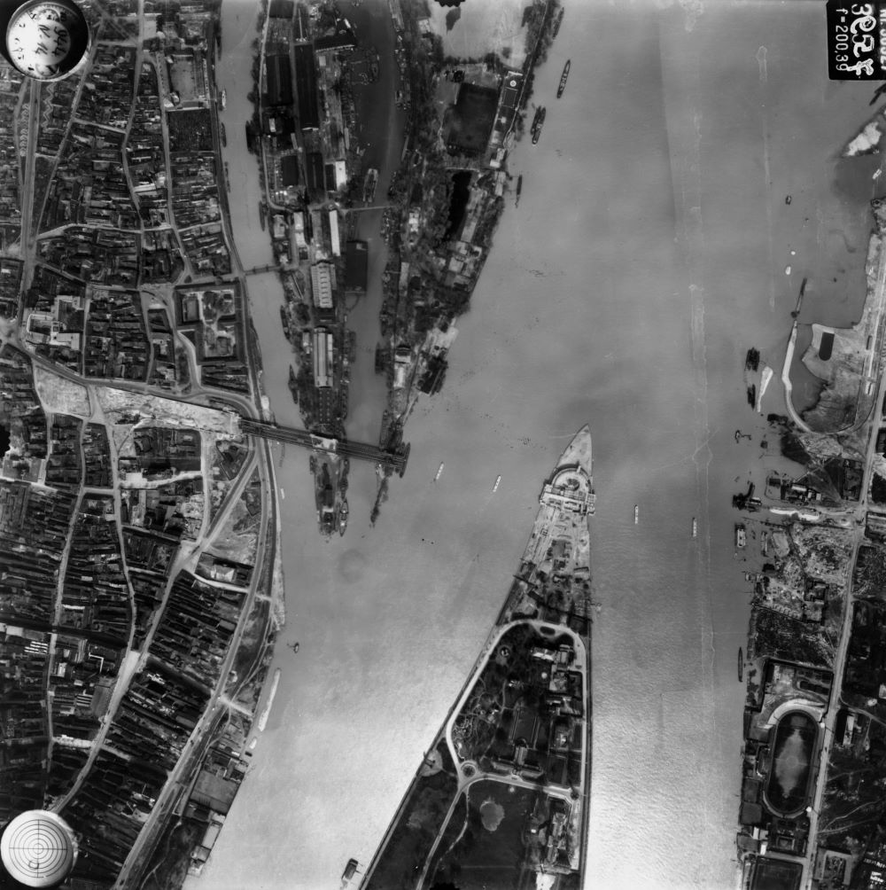 A légifotón a Margit-sziget északi csúcsa és a Hajógyári-sziget déli vége látszik az épülő Árpád híd elemeivel 1944. április 14-én.