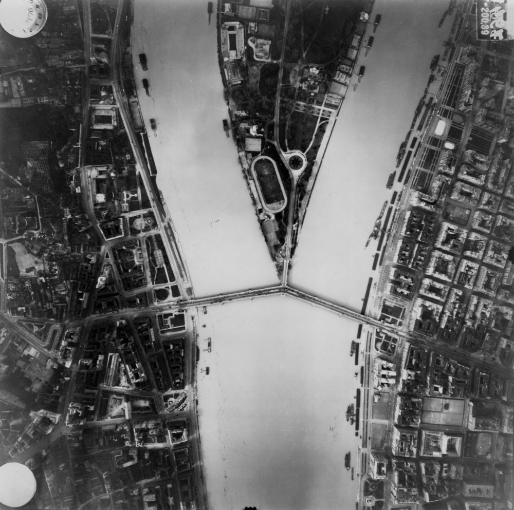 A légifotón a Margit-sziget északi csúcsa és a Hajógyári-sziget déli vége látszik az épülő Árpád híd elemeivel 1944. április 14-én.